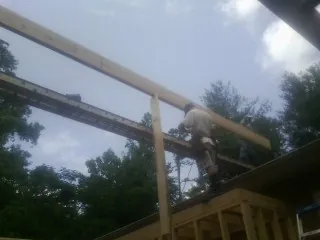 Carpenter setting a ridge beam over a new addition frame — Ice Dam Removal by Roofing Brothers in Pomfret Center