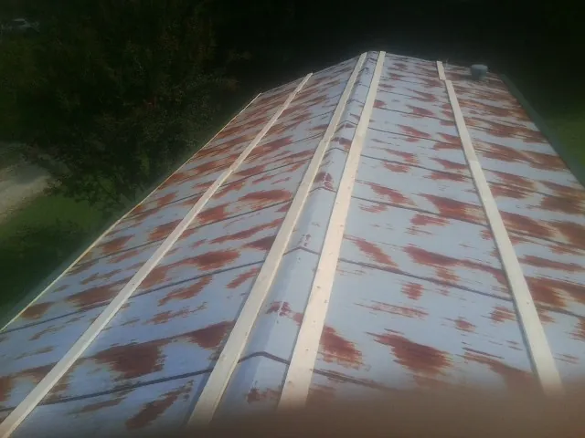 Rusted metal roof panels with new wood purlins before replacement — Storm Damage Roof Repair in Pomfret Center by Roofing Brothers