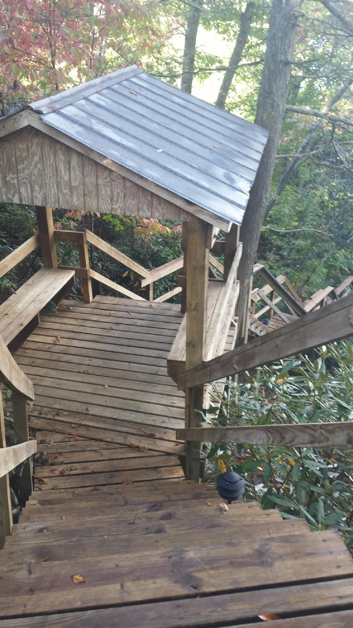 Metal roofed shelter over wooden steps on a wooded walkway — Skylight Repair & Installation work by our crew in Pomfret Center