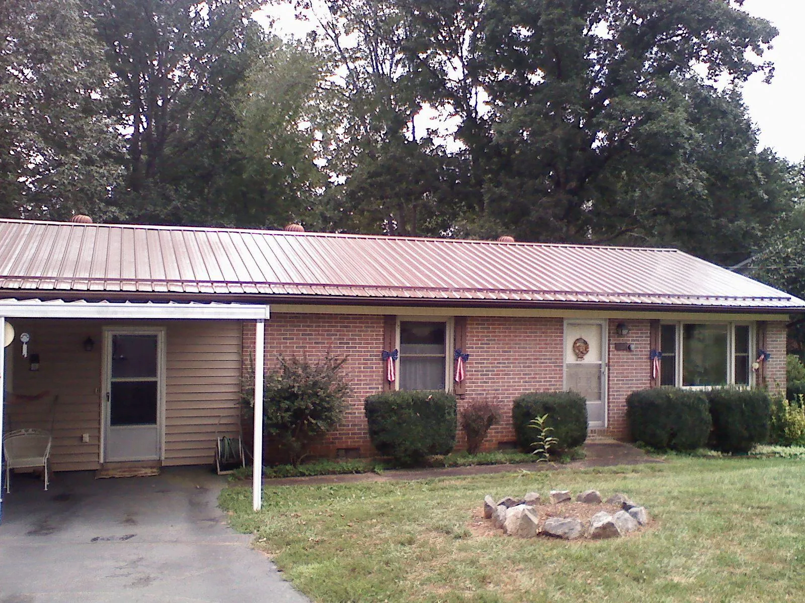 Bronze metal roof and carport on a brick ranch home — Roof Repair work by our crew in Pomfret Center
